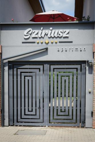 a pair of garage doors in front of a building at Szíriusz Apartmanház in Gyula