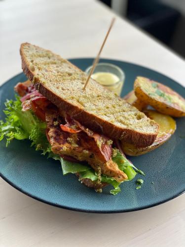 a sandwich on a blue plate with a pickle at Saltstraumen Hotel in Saltstraumen