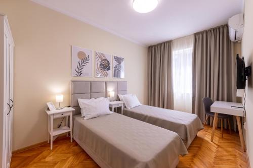 a hotel room with two beds and a window at Perfect Spot Apartment in Varna City