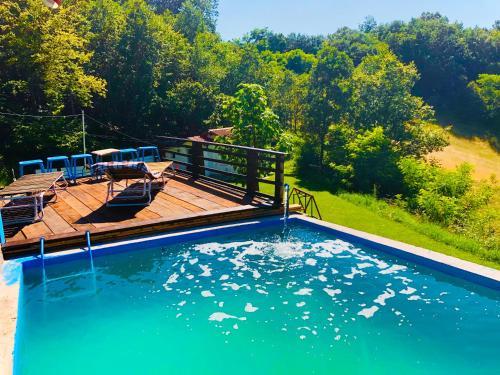 uma piscina com cadeiras e uma mesa num deque em Villat Bardhoshi em Kosovska Mitrovica