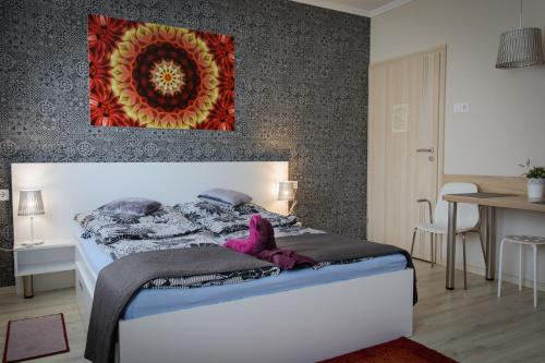 Un dormitorio con una cama con un animal de peluche púrpura. en Szíriusz Apartmanház, en Gyula