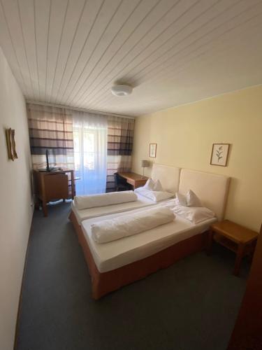 a large bedroom with two beds and a desk at Gasthof Seiser in Straßburg in Kärnten