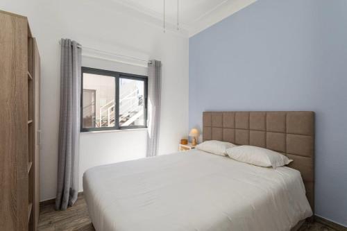 - une chambre blanche avec un grand lit et une fenêtre dans l'établissement Albufeira BeachFront RC, à Albufeira