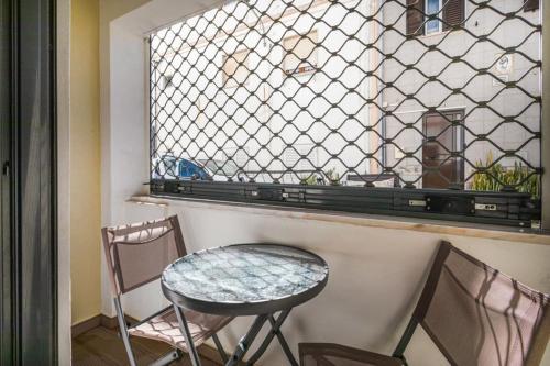 - une table et des chaises dans une chambre avec fenêtre dans l'établissement Albufeira BeachFront RC, à Albufeira