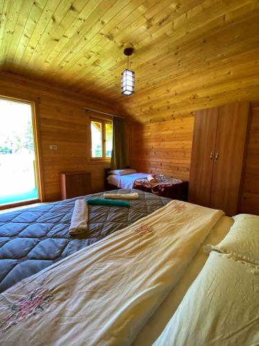 a bedroom with a large bed in a wooden cabin at Hotel Tradita Valbonë in Valbonë