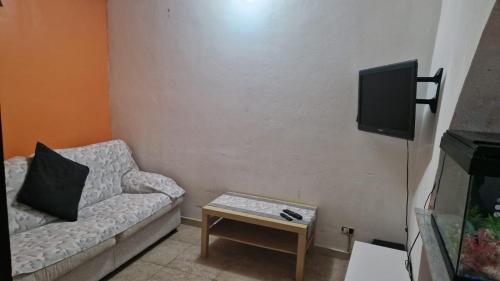 - un salon avec un canapé et une télévision dans l'établissement Chez Taii, à Serralta