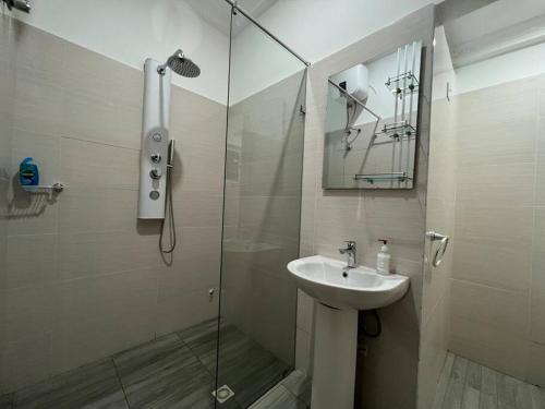 a bathroom with a sink and a glass shower at Luxury WellingManor Apartment in Accra