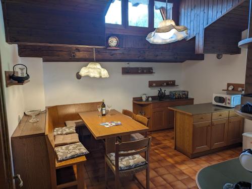 a kitchen with wooden cabinets and a table with chairs at Appartement Il Gallo in Forno di Zoldo