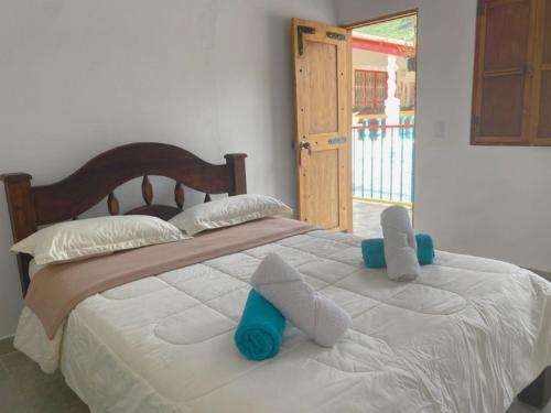 1 dormitorio con 1 cama con toallas en Hotel Cafetero Valparaíso, en La Vega
