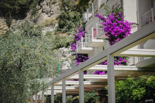 a building with purple flowers on the balconies at Hotel Baia Azzurra - Lake Front in Nago-Torbole