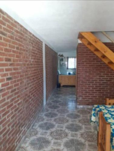 una camera con un muro di mattoni e un pavimento in mattoni di Perla Mar a Santa Clara del Mar