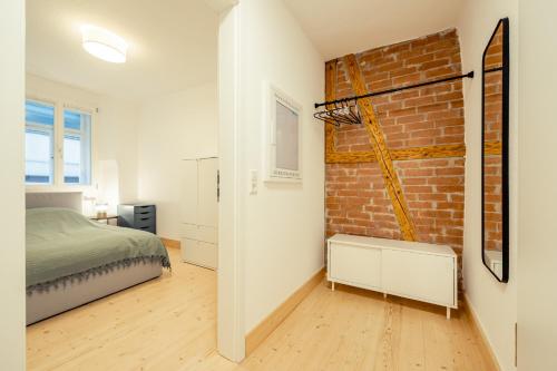 1 dormitorio con cama y pared de ladrillo en Apartment für 4 Aalen Zentrum Netflix 300 Mbit Wlan, en Aalen