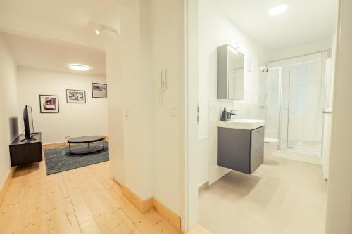 a white bathroom with a sink and a mirror at Apartment für 4 Aalen Zentrum Netflix 300 Mbit Wlan in Aalen