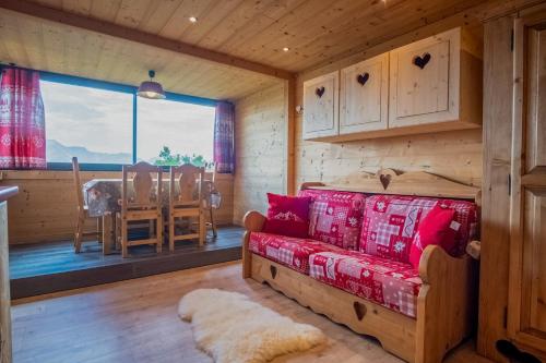 a log cabin living room with a couch and a window at Apartment with a superb view in l'Alpe d'Huez - Welkeys in LʼHuez