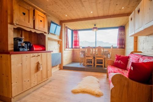 a living room with a red couch in a cabin at Apartment with a superb view in l'Alpe d'Huez - Welkeys in LʼHuez