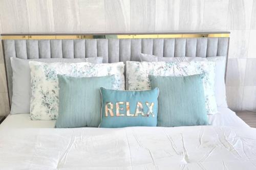 a bed with blue and white pillows on it at A Perfect Escape - Sea facing in Ras al Khaimah
