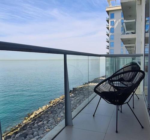 a chair sitting on a balcony looking at the ocean at A Perfect Escape - Sea facing in Ras al Khaimah