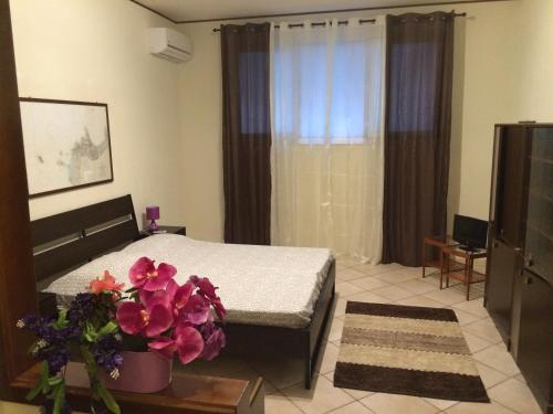 una camera con letto e tavolo con fiori di Villa Giuliana a San Vito lo Capo