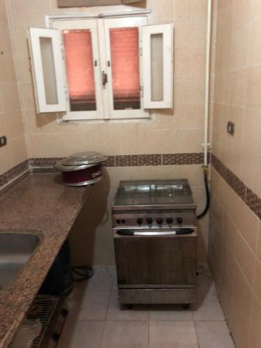 a small kitchen with a stove and a sink at شقة مصيفية بدمياط الجديدة قريبة من الشاطئ والخدمات in Dumyāţ al Jadīdah