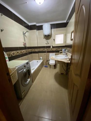 a bathroom with a washing machine and a sink at Luxury Apartment in Port Said
