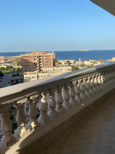 a balcony with a view of the ocean and buildings at Luxury Apartment in Port Said