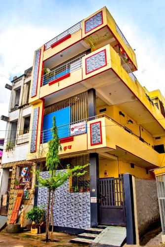 a yellow building with a tree in front of it at Mangal kripa homestay in Ujjain