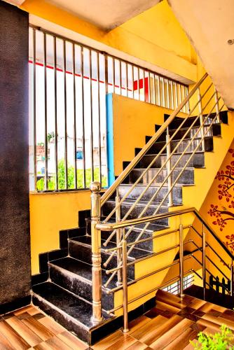 a staircase in a building with a yellow wall at Mangal kripa homestay in Ujjain