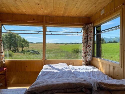 una cama en una habitación con una ventana grande en bieszczadzki holender, en Lipie