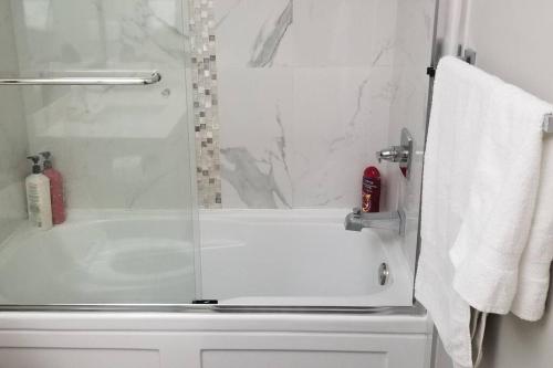 ein Bad mit einer Dusche, einer Badewanne und einem Waschbecken in der Unterkunft Basement Suite 1 queen bedroom(Brand New House) in Coquitlam