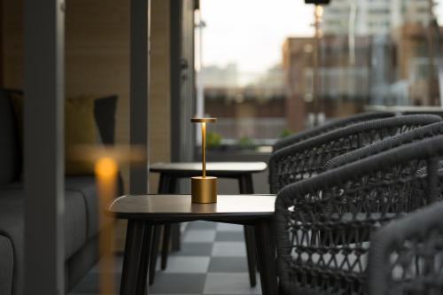 a small table with a candle on it on a balcony at The Parker Hotel and Rooftop in Vancouver