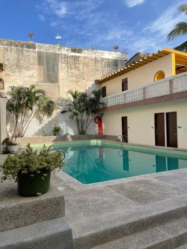 a swimming pool in front of a house at Hotel Ayenda Skall 1319 in Barranquilla