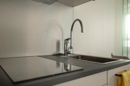 a kitchen with a sink and a counter top at Tampere Kannen Topaasi - Apartment by the Nokia Arena in Tampere