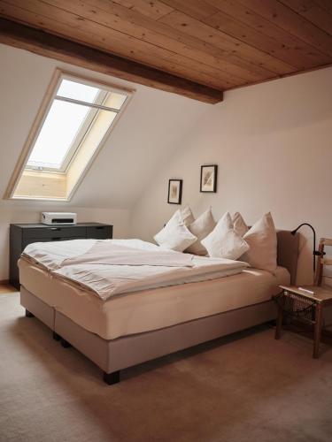 a bedroom with a large bed with a window at Aigen 13 - Dreiviertelhof im Waldviertel in Aigen