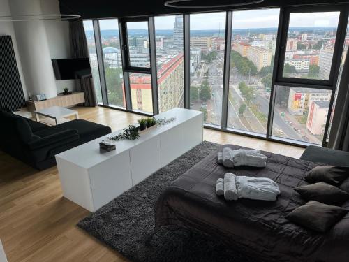 uma sala de estar com uma cama e uma grande janela em Hanza Tower - Luxurious Apartment 60m2 - 15th Floor City View em Szczecin