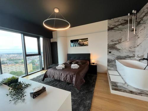 um quarto com uma banheira, uma cama e um lavatório em Hanza Tower - Luxurious Apartment 60m2 - 15th Floor City View em Szczecin