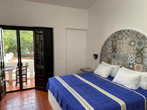 a bedroom with a bed with a blue comforter at Casa Yollotzin in Ajijic