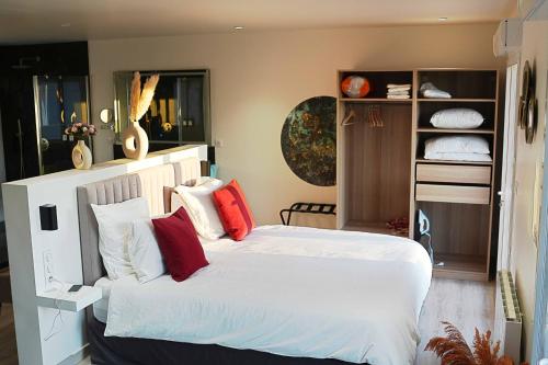 1 dormitorio con 1 cama blanca grande con almohadas rojas en 4AS Spa Paris, en Verdelot