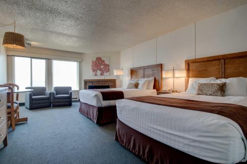 um quarto de hotel com duas camas e uma cadeira em Ester Lee Motel em Lincoln City