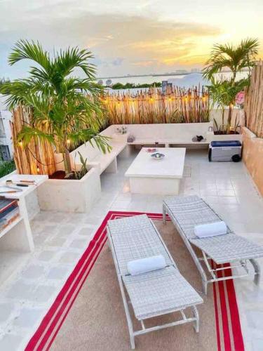 a rooftop patio with two benches and a table at Rooftop penthouse 3 bedrooms, Sleeps 8! in Cancún