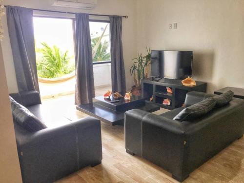 a living room with two couches and a television at Rooftop penthouse 3 bedrooms, Sleeps 8! in Cancún