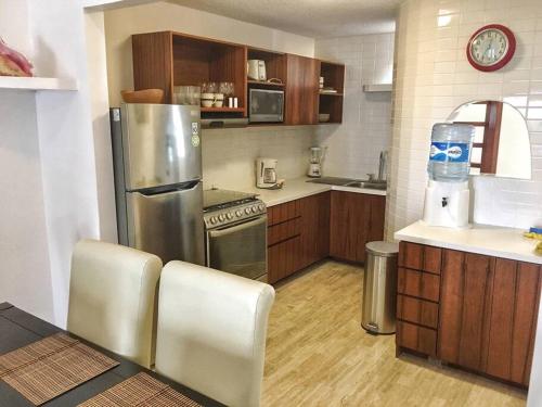 a kitchen with a stainless steel refrigerator and wooden cabinets at Rooftop penthouse 3 bedrooms, Sleeps 8! in Cancún