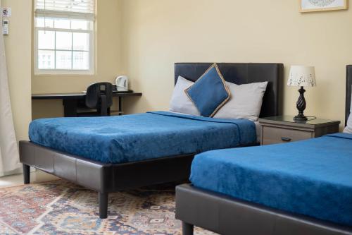 um quarto com 2 camas com lençóis azuis e uma secretária em GC Resort em St Mary