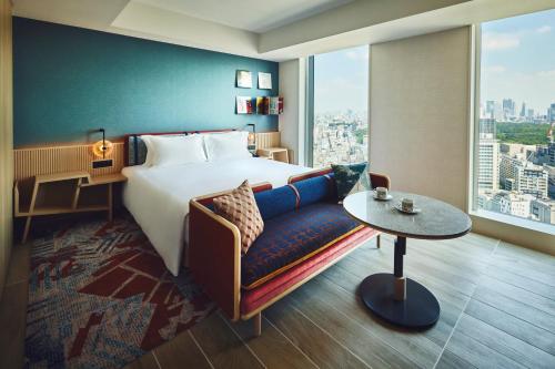 une chambre d'hôtel avec un lit, un canapé et une fenêtre dans l'établissement Hotel Indigo Tokyo Shibuya, à Tokyo