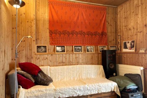 um quarto com uma cama numa parede de madeira em Charmante maison individuelle em Les Verrières