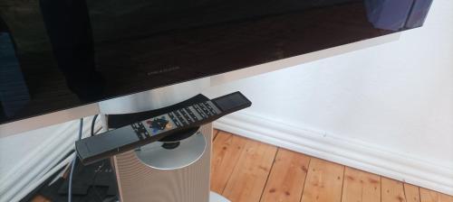 a tv sitting on a stand with a remote control at Prestige Citycenter Appartment mit Terrasse in Detmold