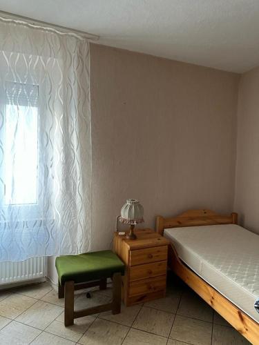 a bedroom with a bed and a chair and a window at Ferienwohnung Vogtei7 in Senheim