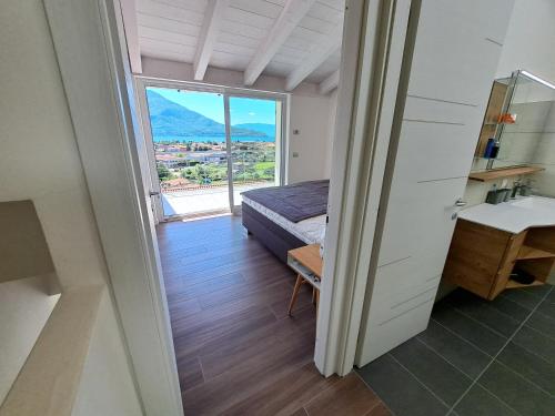 a bedroom with a bed and a large window at Immobillario - Lakes Dream in Domaso