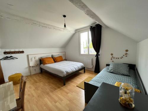 a bedroom with a bed and a table in it at Gîte Au Coeur d’Azay in Azay-le-Rideau