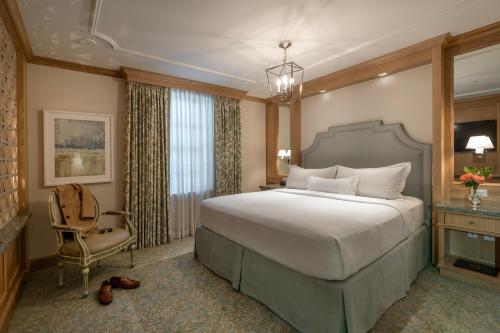 a bedroom with a large bed and a chair at Hotel Monteleone in New Orleans