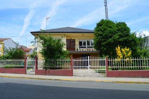 een geel huis met een wit hek bij Casa completa e independiente en centro de Melide in Melide